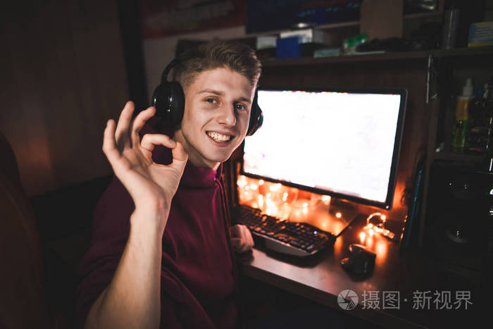 一个青少年的肖像在晚上使用电脑,显示ok.