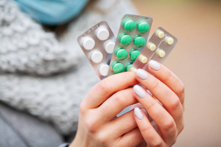 秋季感冒感冒和流感.妇女在秋天公园拿着药片照片