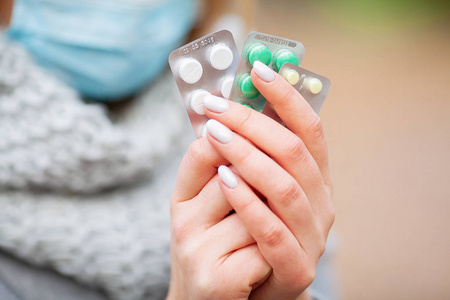 感冒和流感.妇女在秋天公园拿着药片照片