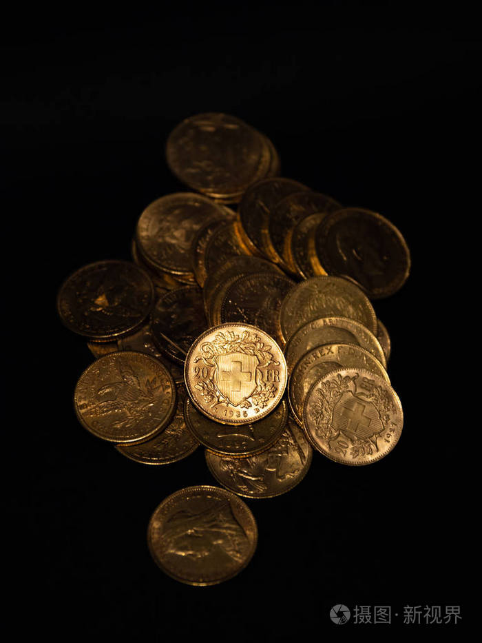 接近真正的金币硬币堆放在黑暗的背景上