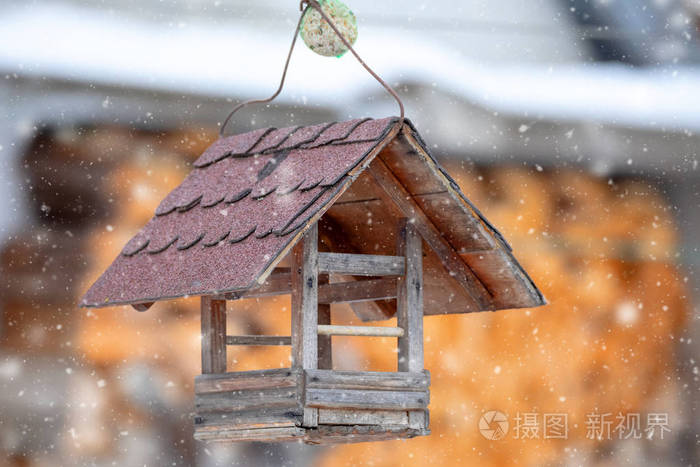 在寒冷的日子里，用木鸟饲养树屋吊死了，用来喂养花园里的雪鸟