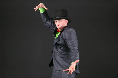 戴着弓手帽的魔术师正在黑色背景上施展魔法.照片