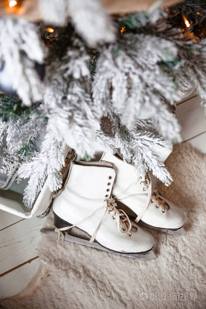 s skates for figure skating white lie next to the Christmas tree