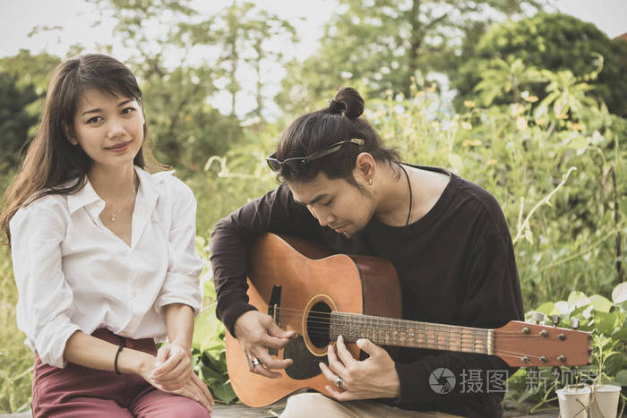 亚洲年轻男女弹吉他幸福情感