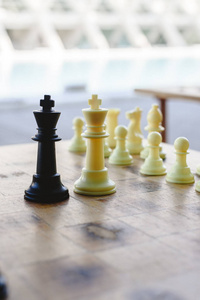 黑白棋王面对离焦的棋子在木板上。