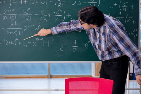 年轻有趣的数学老师在黑板前