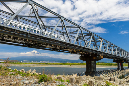 富士山和运动北海道新干线或子弹头列车在铁路上。 新干线超高速铁路由日本铁路公司运营。