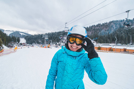 滑雪设备上年轻微笑的女人的肖像。 冬季体育活动。 玩得开心