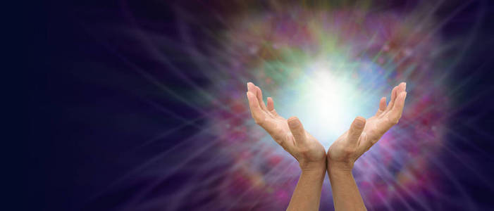 给你温柔的疗愈能量女性双手向上面对一个美丽的彩色能量形成，左边有一个复制的空间