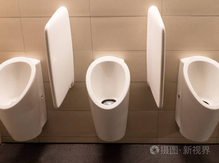 干净的白色现代陶瓷小便池在现代公共厕所为男性