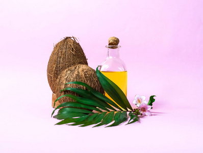 椰子油和新鲜椰子分离。由椰子和叶子制成的绿色背景的创意布局