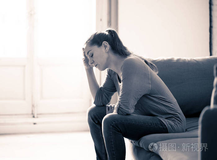 年轻有吸引力的拉丁女人躺在家里客厅沙发上感到悲伤疲倦和担忧患有