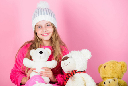 泰迪熊帮助孩子们处理情绪和限制压力。熊玩具收藏。小女孩顽皮地拿着泰迪熊毛绒玩具。孩子小女孩玩与软玩具泰迪熊在粉红色的背景