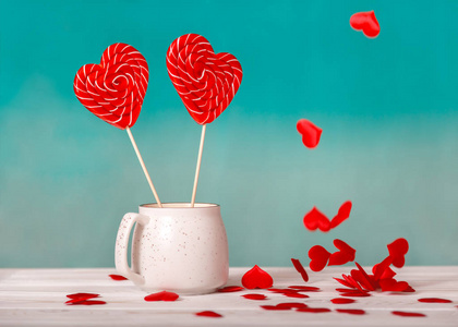 s day background. Two Lollipop in heart shape in a white Cup on 