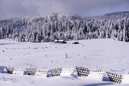 防雪雨的安全栅栏。 雪栅栏冬季景观路边。