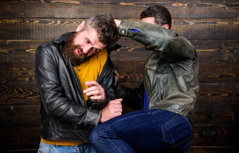 街头打斗的概念.男子残酷的流氓穿着皮夹克战斗照片