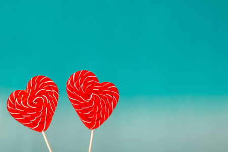 s day background. Two Lollipop in heart shape on a turquoise blu