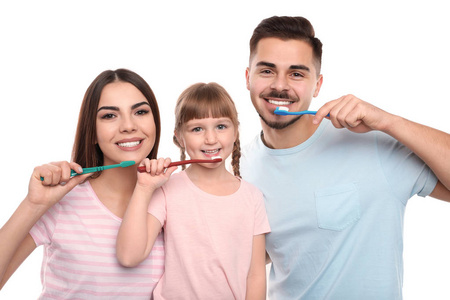 小女孩和她的父母一起在彩色背景下刷牙