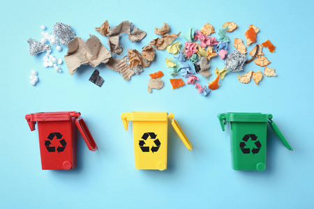 垃圾桶和不同的垃圾在彩色背景顶部视图. 废物回收概念照片