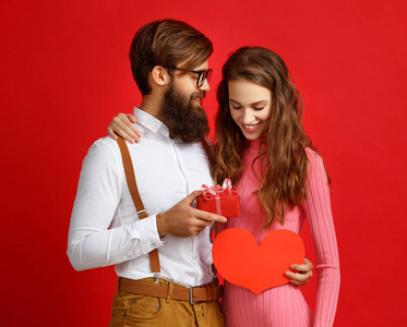 s day concept. happy young couple with heart, flowers, gift on r