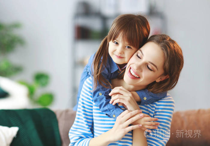 幸福的爱的家庭一个母子的女儿拥抱在家里