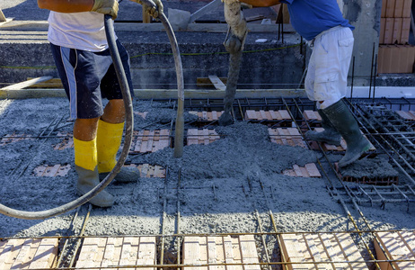 建筑工人在混凝土浇筑工程中以钢筋形式压实液态水泥