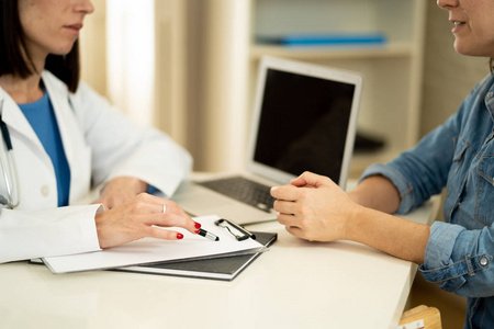 医生和病人正在讨论临床医院办公室在保健和助理概念方面的症状诊断和