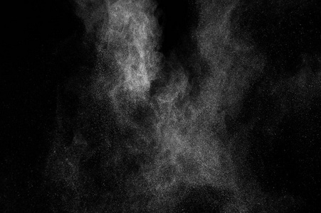 白色粒子在黑色背景上的冻结运动。 粉末爆炸。 抽象灰尘覆盖纹理。