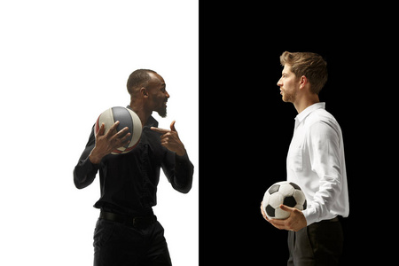 一个微笑的人的画像拿着橄榄球和篮球在白色和黑色背景查出了