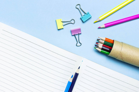 木制彩色铅笔清洁学校笔记本在线回形针上的蓝色背景顶部视图平躺复制空间。 用于绘画物体的铅笔来创造创造力。 回到学校的概念