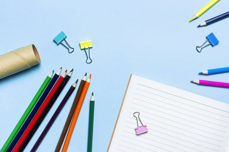 木制彩色铅笔清洁学校笔记本在线回形针上的蓝色背景顶部视图平躺复制空间。 用于绘画物体的铅笔来创造创造力。 回到学校的概念