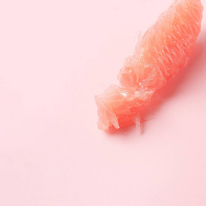 红葡萄柚片上糊粉色背景。最少的健康新鲜水果。葡萄柚肉质果肉。时尚色彩的2019年活珊瑚最小时尚概念。文本的复制空间。