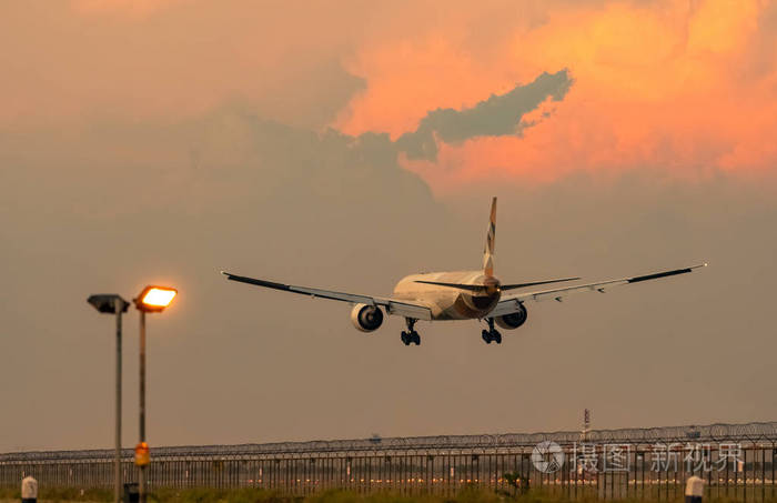 抵达航班.飞机飞越跑道.晚上安全飞行的围栏和滑行道照明.