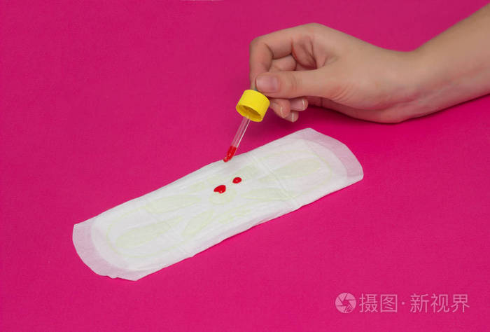 一个女孩在女性垫圈上滴血月经, 关键天的概念, 粉红色的背景, 特写