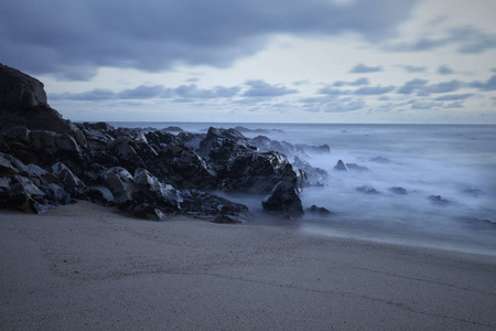 岩石海景在黄昏的蓝色时刻。 葡萄牙北部海岸。 长期暴露。