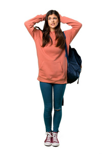 一个穿着运动衫和背包的青少年女孩因为偏头痛而将手放在头上