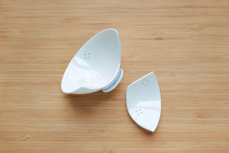 木材背景上破碎的陶瓷碗. 上面的风景.照片