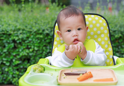 亚洲婴儿男孩吃婴儿引导断奶BLW。 手指食物的概念。