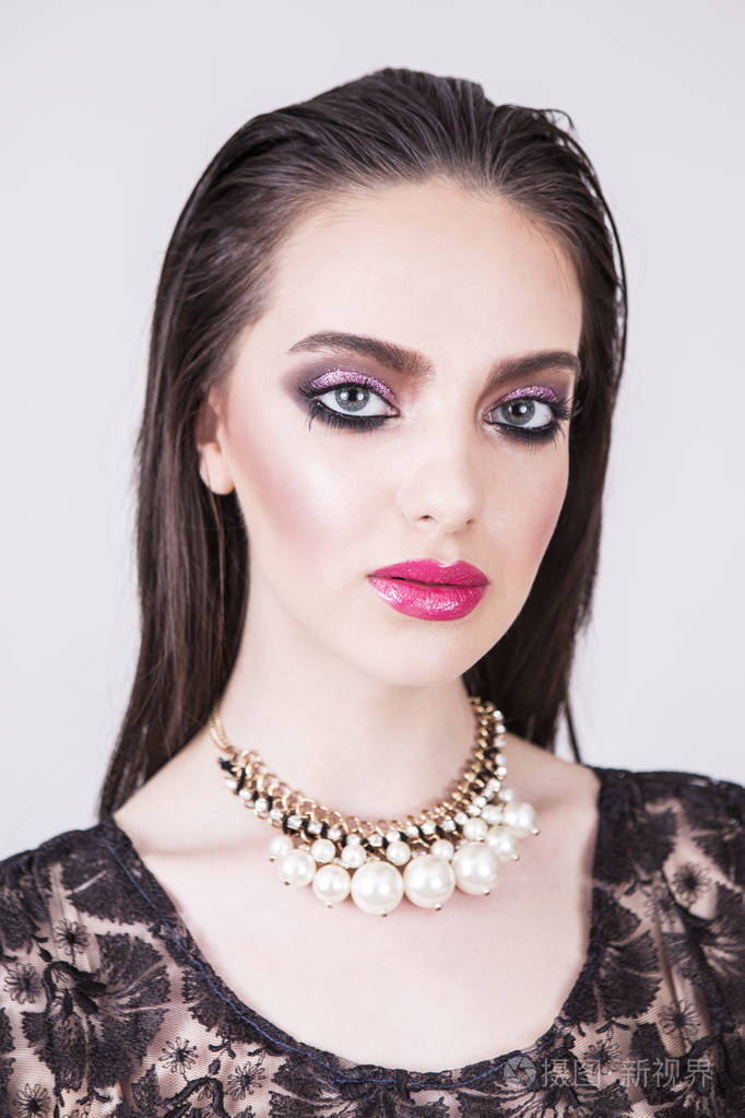 性感的黑发女孩,有着迷人的绿色大眼睛. 垂直摄影棚拍摄.