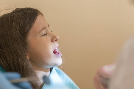 s . little girl sitting in a chair near a dentist after de