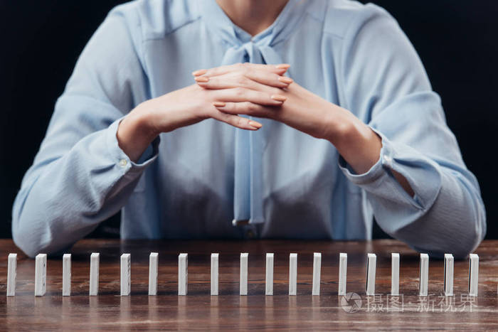 女人的部分视野双手交叉多米诺骨牌孤立在黑色上