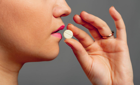 s hand with a pill and the mouth. Closeup