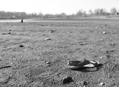 在一个黑白两色的的泥滩上丢失的凉鞋