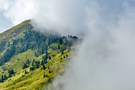 瓦尔帕达山脉山谷，绿草和树木。 穿过云层。 意大利白云石美女
