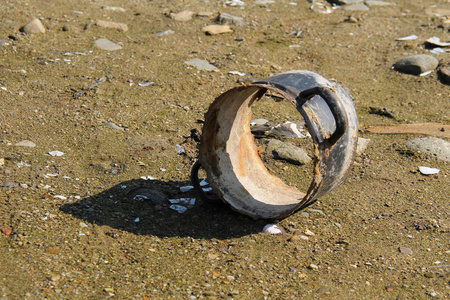 池塘泥滩上的破锅照片