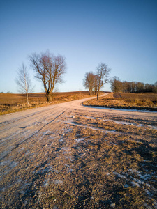 阳光明媚的冬日，空旷的乡村景观，白雪覆盖大地，照片中的道路和平与和谐的理念