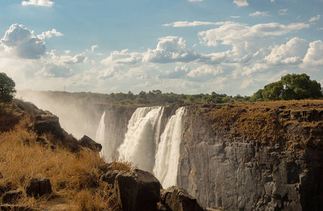 维多利亚上空的彩虹落在赞比齐河上。 维多利亚瀑布是南非南部的瀑布，位于赞比亚和津巴布韦边境的赞比齐河上。