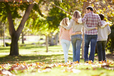 一家人走过秋天的树林