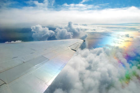 天空中在云层上飞行的飞机的机翼