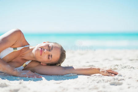 躺在沙滩上放松的年轻女子